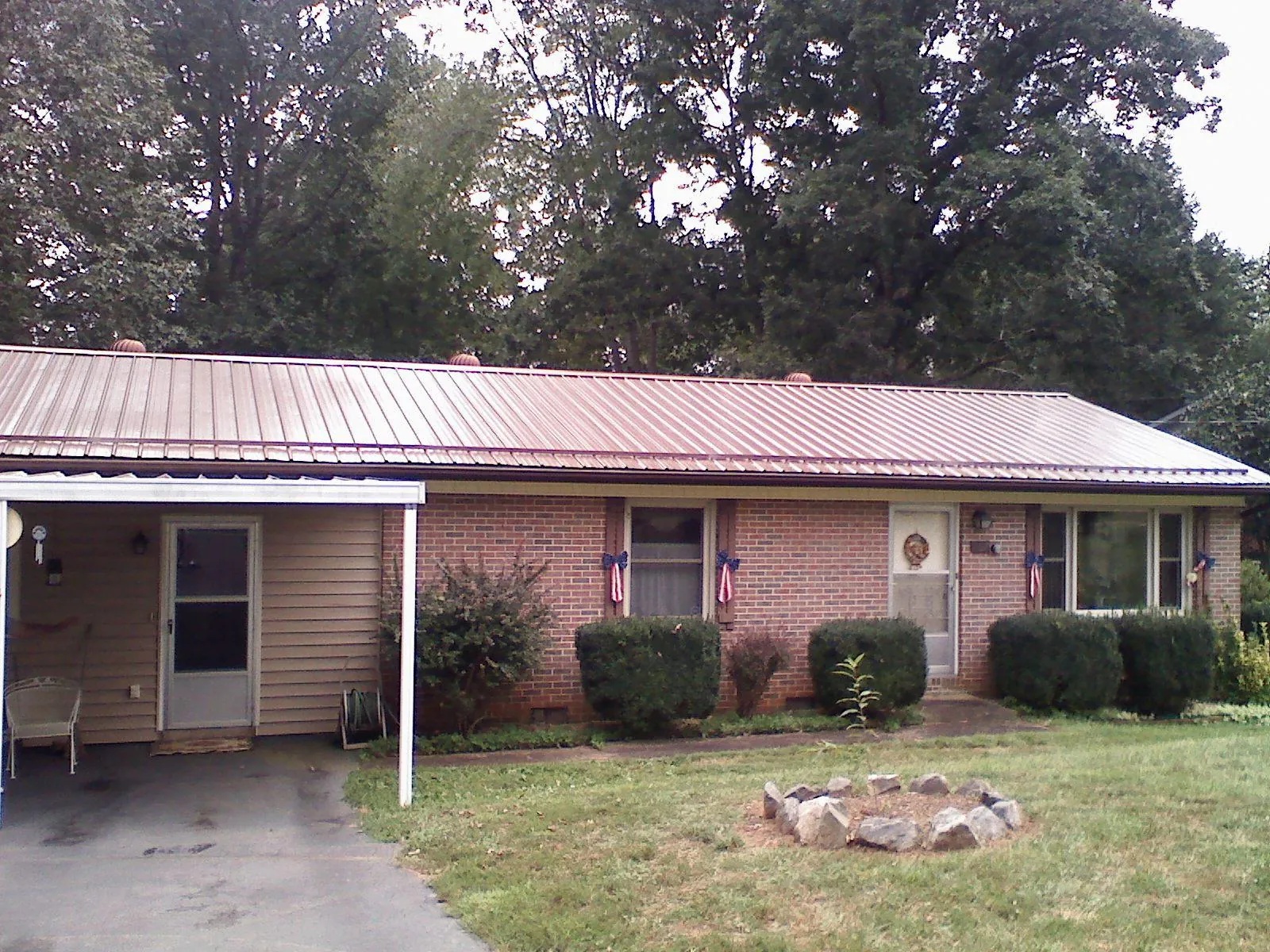 Bronze metal roof and carport on a brick ranch home — Roof Repair work by our crew in Greenland