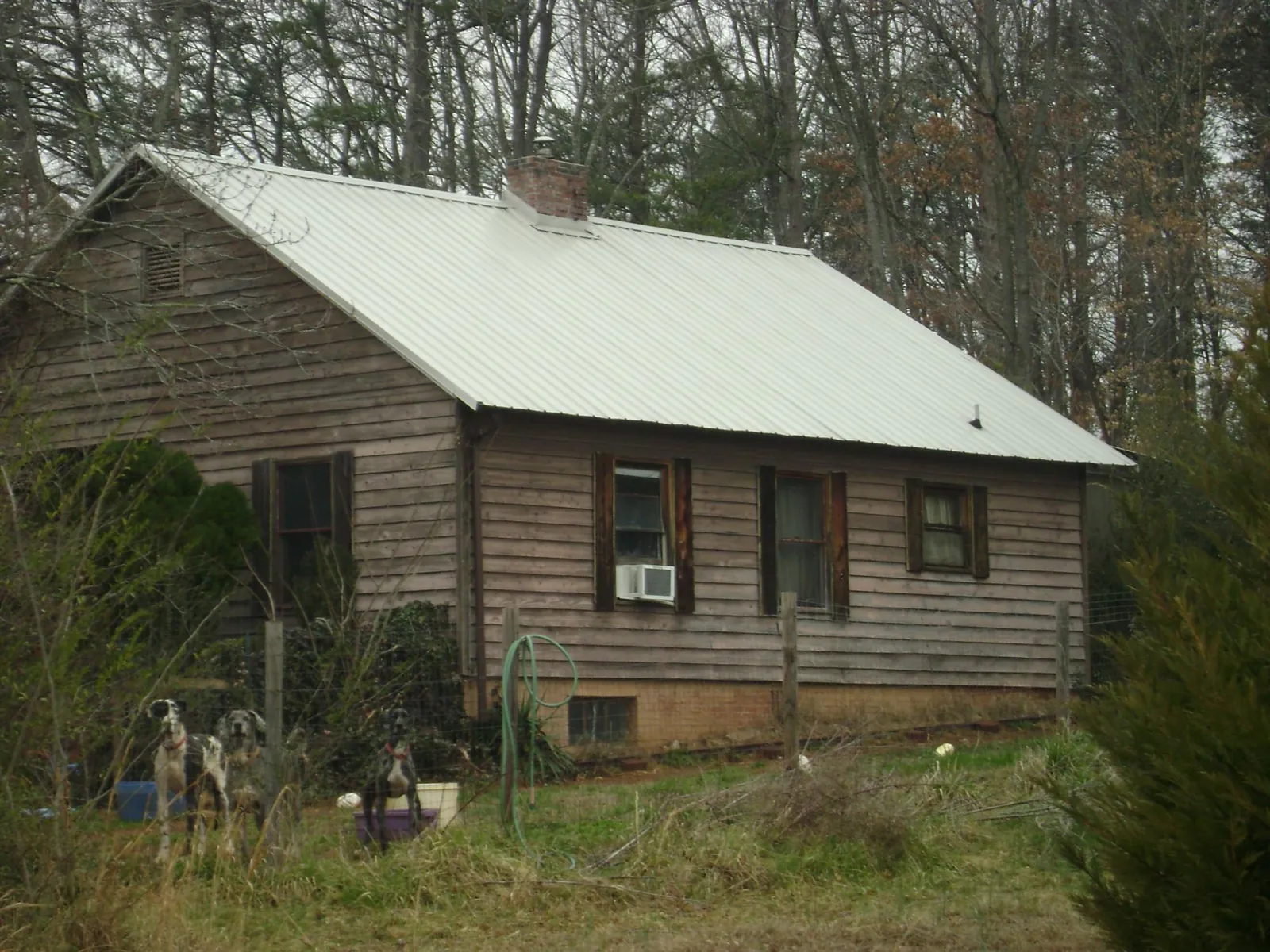 White metal roof on an old wood sided farmhouse, from a Metal Roof Installation job in Greenland